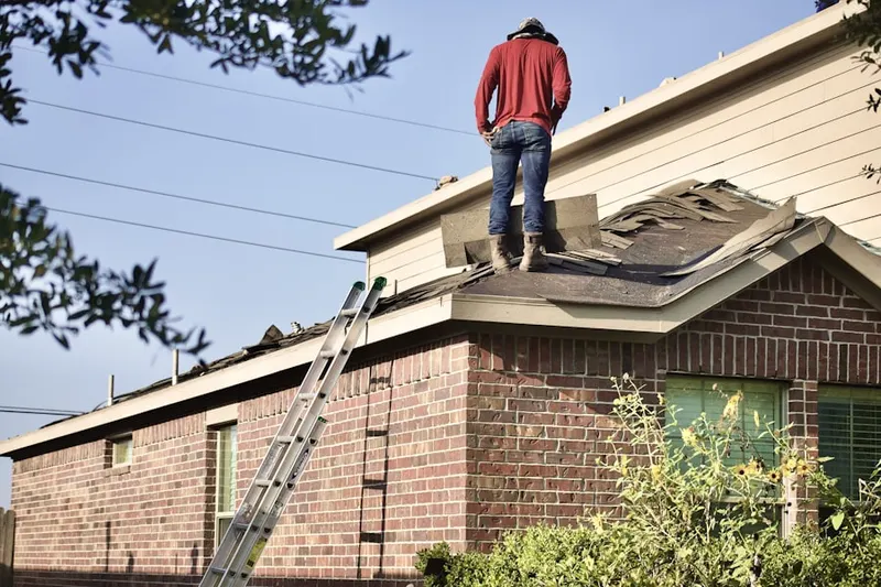 Professional roofer working on a residential roof in Harper Woods